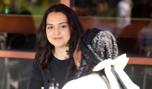 Students sitting talking to each other, one student is facing the other